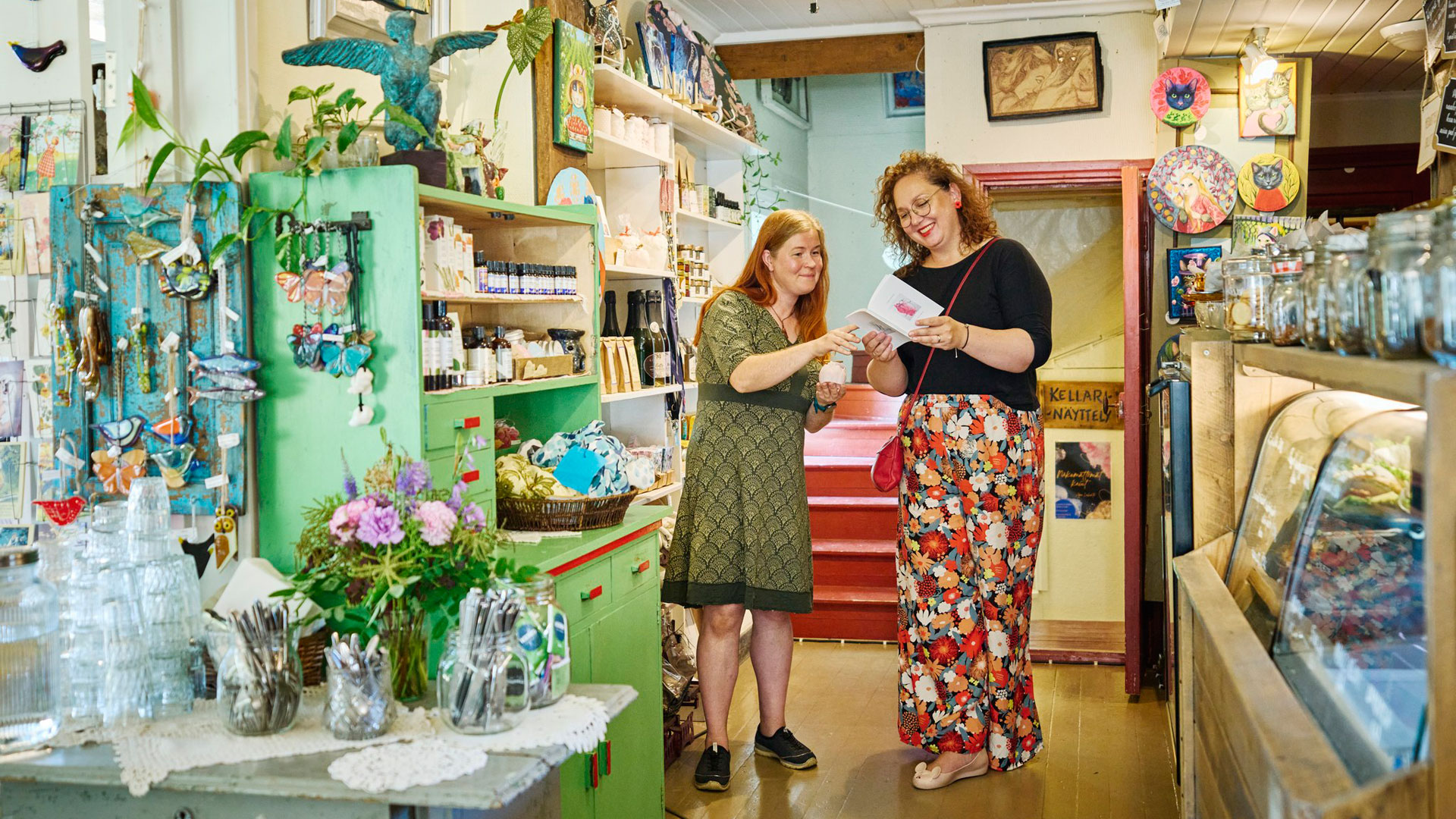 Kaksi naista tutkii kirjaa kaupassa,.